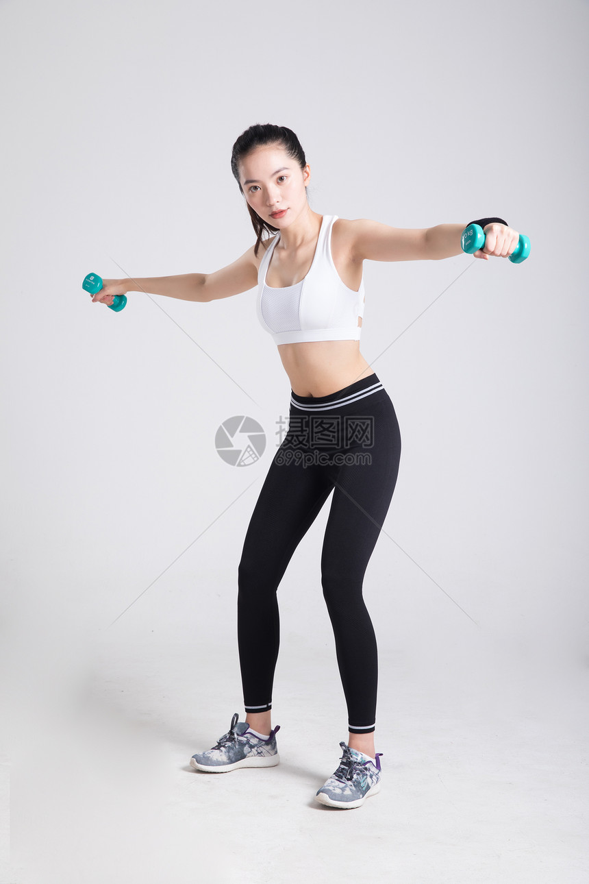 年轻女性健身哑铃侧平举动作图片