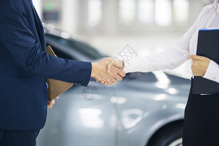 商务开车销售员与顾客握手背景