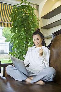 年轻女性在沙发上看电脑图片