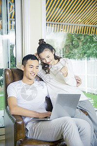 年轻夫妇在客厅玩电脑图片