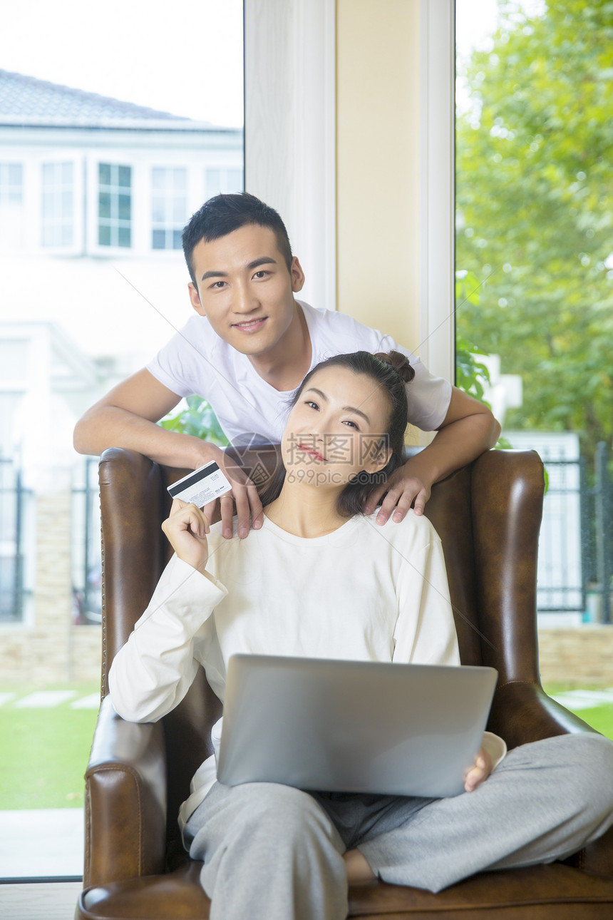 年轻夫妇在客厅用电脑网购图片