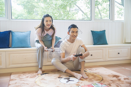 年轻情侣在客厅打游戏背景图片