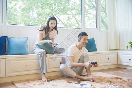 年轻情侣在客厅打游戏背景图片