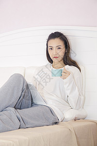 年轻女性在卧室喝咖啡图片