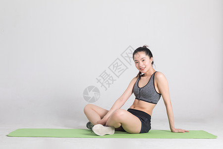坐在瑜伽垫上休息的运动女性图片