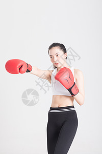 戴着拳击手套打拳出拳的年轻运动女性图片