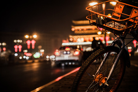 汽车自行车夜色中的摩拜单车和钟楼背景