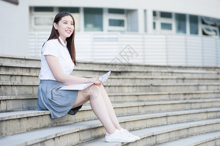 坐着台阶上坐在校园台阶上的大学生背景