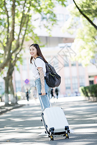 毕业季拖行李校园里拖着行李箱的女生背景