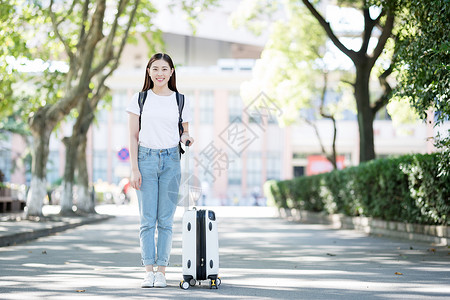 毕业季拖行李校园里拖着行李箱的女生背景