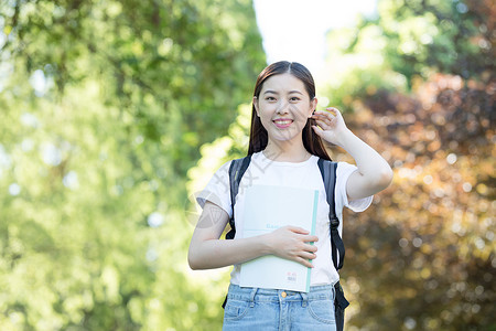 背着书包走在校园里的大学生图片