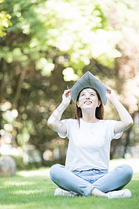 愉快地坐在草坪上学习的女同学图片