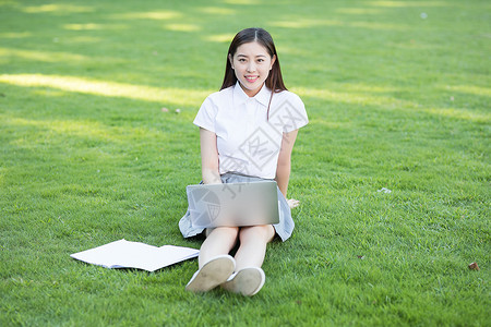 绿色草坪上休闲学习的女生图片