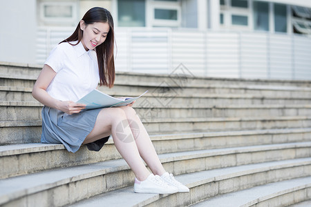 坐着台阶上坐在学校台阶上看书的女同学背景