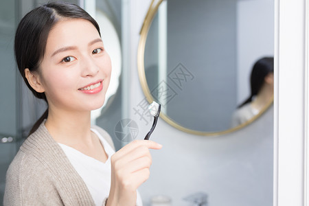 早起洗手间刷牙的年轻 女性背景图片