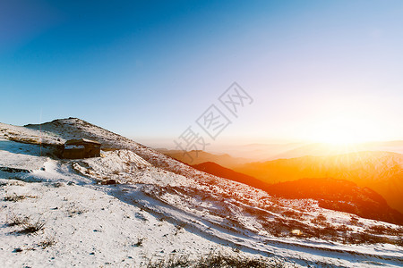 冬天温暖阳光冬季雪山的日出背景