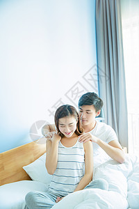 年轻情侣在床上按摩背景图片