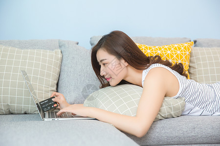 年轻女子在沙发上网购背景图片