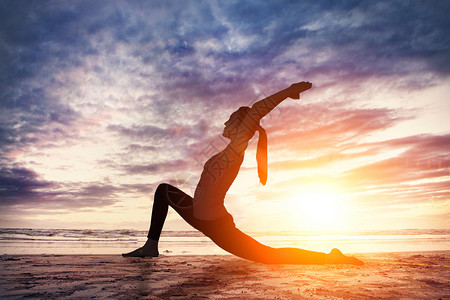 黄昏海滩在黄昏下锻炼瑜伽设计图片