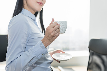 在办公室喝咖啡的自信职业女性背景图片