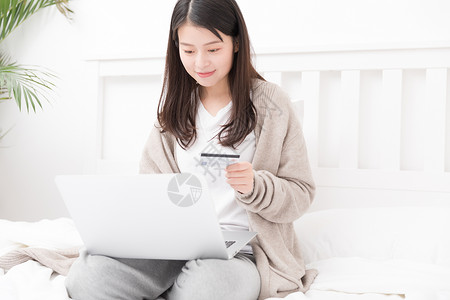 互联网女生插画拿着信用卡在床上网购的女生背景