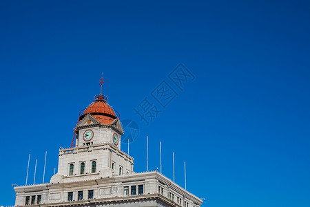 蓝色时钟光效光蓝天下的建筑背景