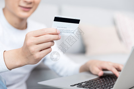 信用卡使用拿着银行卡使用电脑的男性背景