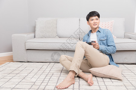 无线遥控器坐在沙发上玩游戏的男子背景