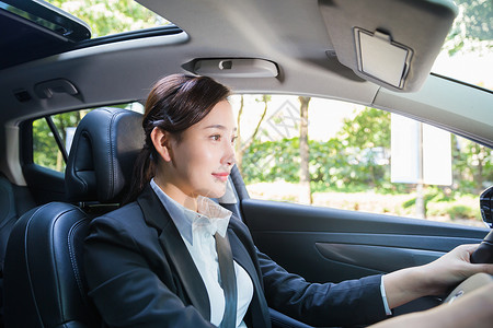 在开车的人商务女性在驾驶汽车背景