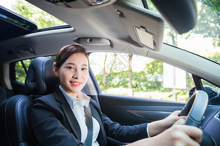 在开车商务女性在驾驶汽车背景