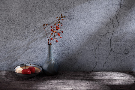玻璃纹路水泥墙角的花瓶和水果碟背景