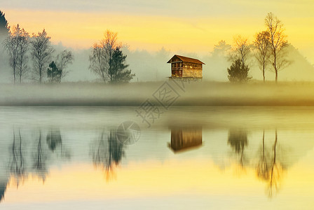 竹筏小屋清晨乡村充满雾气的湖边倒影背景