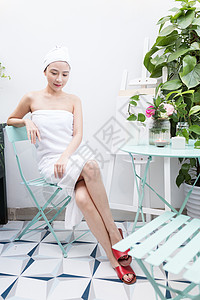 裹着浴巾坐着休息的美女背景图片