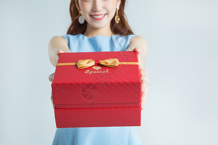 礼品盒图片年轻女性手拿礼物盒棚拍背景