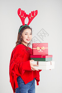 手拿礼物盒的圣诞装扮女性棚拍背景图片