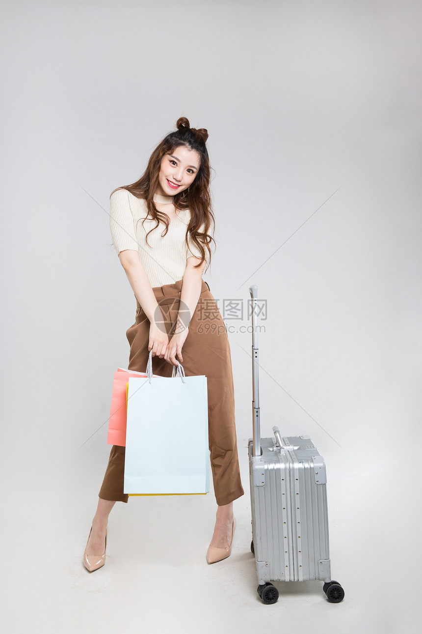 推行李箱购物的时尚女性图片