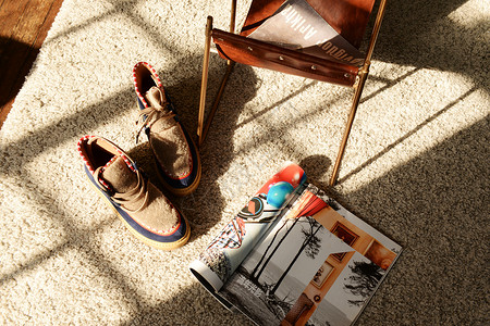 家里休息地毯上的鞋子和杂志背景
