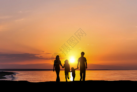 海边玩耍夕阳下家庭剪影设计图片