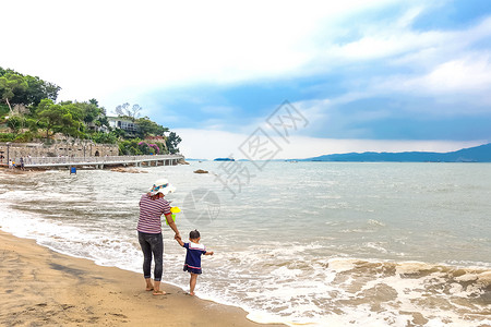 海边旅游的孩子厦门厦大白城沙滩海边的母女背景
