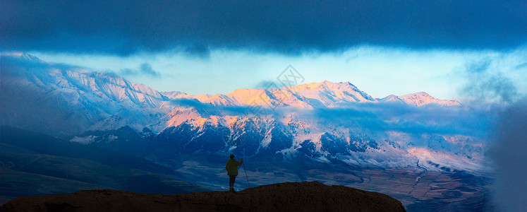 日照雪山与登山者背景图片