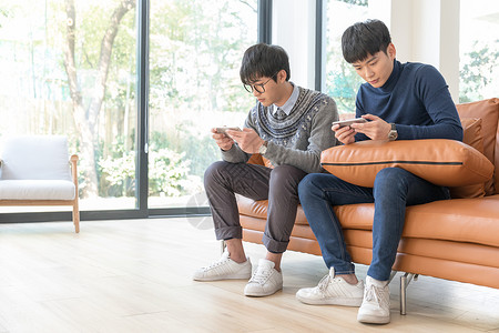 青年男性客厅沙发玩手机坐在客厅里玩手机的年轻人背景
