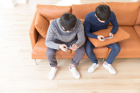 青年男性客厅沙发玩手机坐在客厅里玩手机的年轻人背景