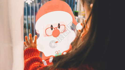 小女孩贴圣诞老人窗花背景图片