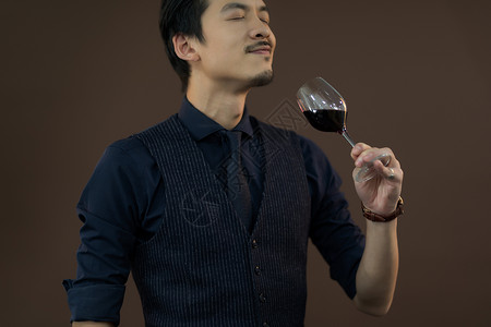 中年男性品尝红酒背景图片