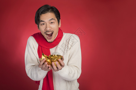 新年男士手拿金元宝背景图片