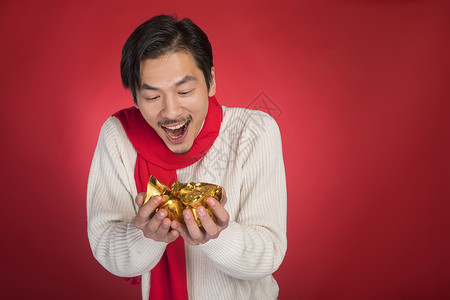 新年男士手拿金元宝背景图片