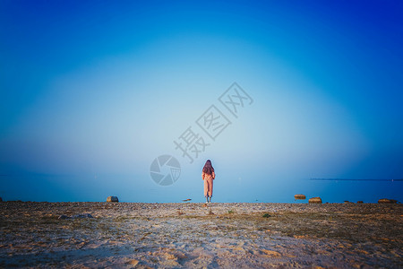 蓝色太阳花边框冬季女孩看海背影背景