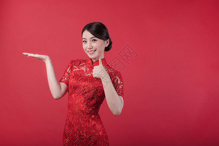 红色旗袍美女新春旗袍美女举大拇指背景