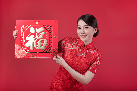 春节穿旗袍的女孩手拿福字高清图片