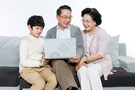 老人和孙子在沙发上玩电脑高清图片